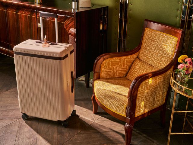 A suitcase next to a yellow arm chair