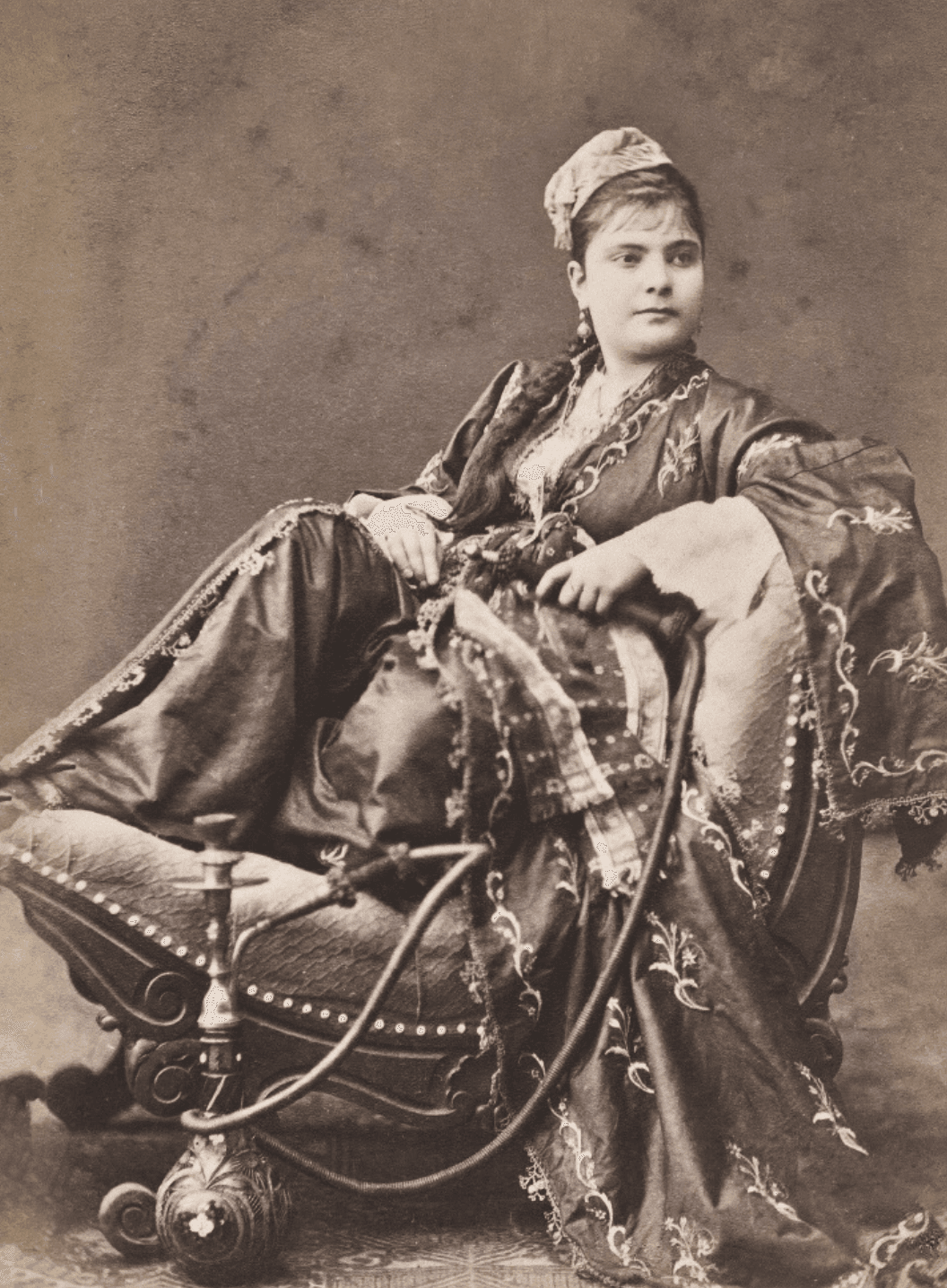 Image may contain Furniture Person Sitting Face Head Chair Clothing Hat Art and Painting