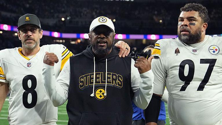 Head coach Mike Tomlin walks off the field with Aaron Rodgers and Cameron Heyward of the Pittsburgh Steelers after beating the Detroit Lions