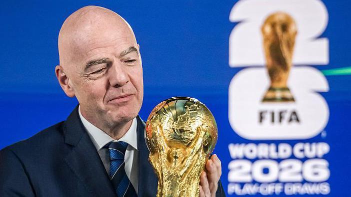Fifa president Gianni Infantino holding the World Cup