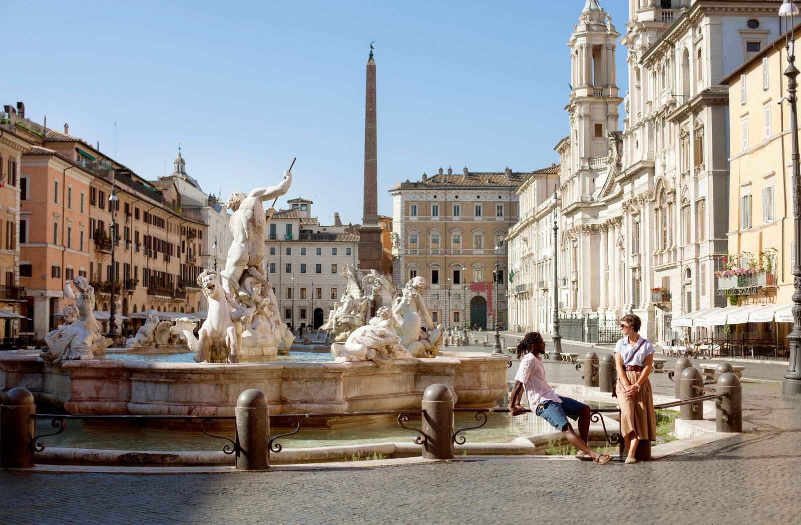 Two people at Bernini fountain in beautifully deserted Piazza Navona Rome Italy