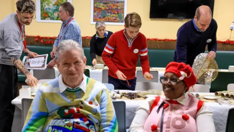Andrew Parsons/Kensington Palace Prince William and Prince George helping set the table for a Christmas lunch at the Passage charity