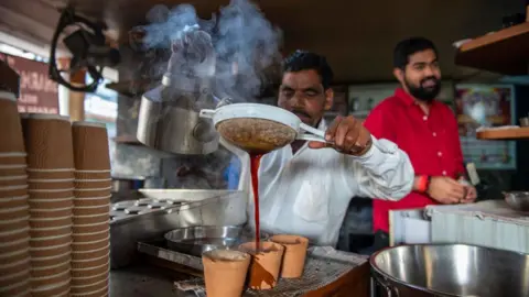 Getty Images A shopkeeper prepares kulhad tea for customers at Sharma tea stall in Hazratganj, Lucknow, India. Tea lovers in Hazratganj, one of the oldest areas in Lucknow, enjoy their first sip of morning tea at the hub of popular stalls serving tea and snacks to the visitors. (Photo by Pradeep Gaur/SOPA Images/LightRocket via Getty Images)