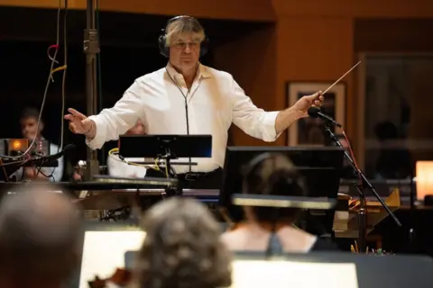 20th Century Studios Simon Franglen conducts the orchestra as he records the soundtrack for Avatar: Fire and Ash