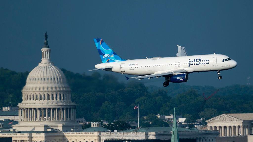 A photo of a JetBlue Airlines Airbus A320 landing in Washington DC.