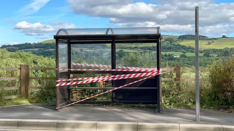 Getty Images A bus shelter sealed off with red and white plastic tape after being vandalised.