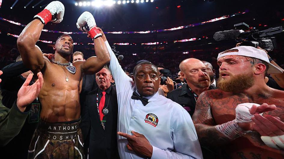Anthony Joshua has his hand raised by the referee after beating Jake Paul by knockout in Miami