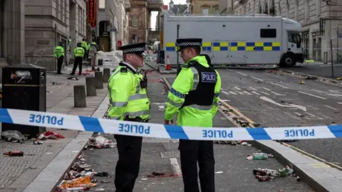 Reuters Police officers work at the scene after an incident where a car ploughed into a crowd of Liverpool fans during a parade