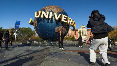 Getty Images Visitors take photos in front of the iconic rotating globe at Universal Beijing Resort