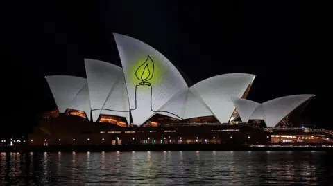Getty Images The image of a candle lit up on the Opera House sails