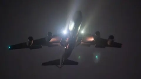 US Air Force/Reuters A night-time image of a military plane taking off from a US airbase, seen from below, with headlights full beam
