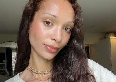 Billie van der Westhuizen A selfie of 30-year-old Billie van der Westhuizen who has long dark wavy hair and is wearing a white jumper