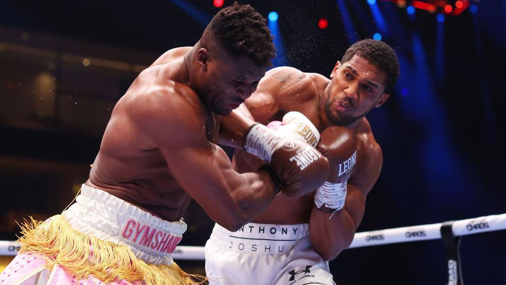 Francis Ngannou falls as he is punched by Anthony Joshua