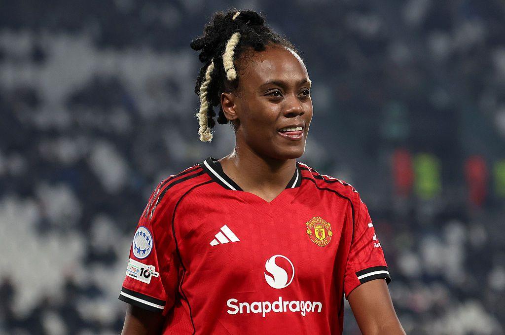 Melvine Malard in Manchester United's red kit with her tongue between her teeth