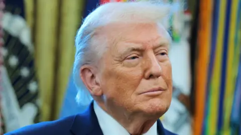 Getty Images President Trump in the Oval office wearing a white shirt and blue suit