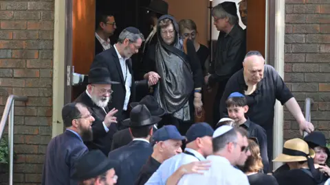 Dean Lewins/AAP/via Reuters Larisa walks down the steps, with a number of other people, at her husband's funeral