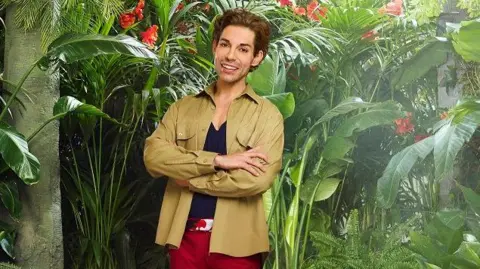 ITV Tom Read Wilson wears a green khaki shirt.