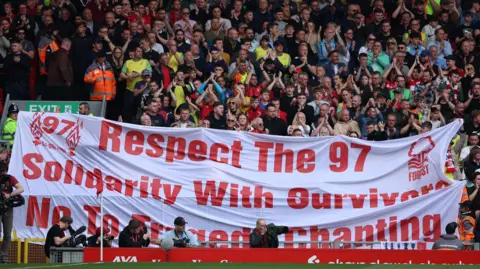 Reuters Football fans  hold up a banner in memory of the 97 victims of the Hillsborough disaster. The banner is white with red writing which reads "respect the 97, solidarity with survivors no to tragedy chanting".