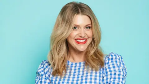 James Rudland Picture of Anna Williamson smiling in a blue and white dress