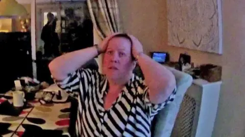 Dyfed-Powys Police A woman with her hands on her heads - she is wearing a black and white top