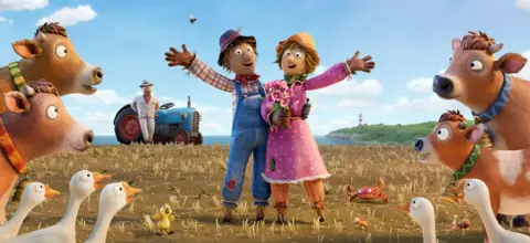 Two scarecrows in a field with a tractor in a background, surrounded by geese and cows