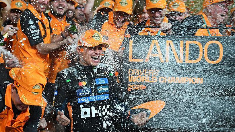 Lando Norris celebrating with McLaren after winning the drivers' championship in Abu Dhabi